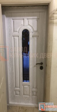 входная дверь с арочным стеклом и ковкой - фото отделки цвета беленый дуб внутри