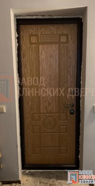 входная металлическая дверь в частном доме с фрезерованной мдф панелью цвета миланский орех внутри.j