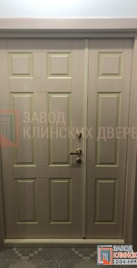 двухстворчатая входная дверь бежевого цвета с классическими филенками и отделкой мдф