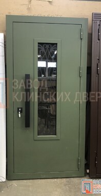 зеленая одностворчатая уличная дверь со стеклом и фигурной решеткой внутри