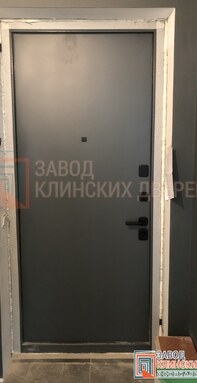 матовая квартирная входная дверь темно-серого цвета с гладкой мдф панелью внутри