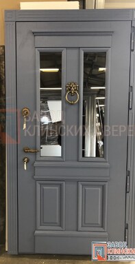 серая входная дверь с верхним остеклением и классическим кованым кольцом-стучалкой