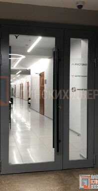 серая полуторная дверь с большими стеклами в офисном здании
