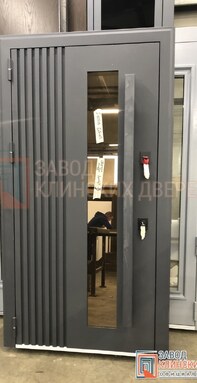 узкая высокая входная дверь серого цвета с длинной вертикальной стеклянной вставкой